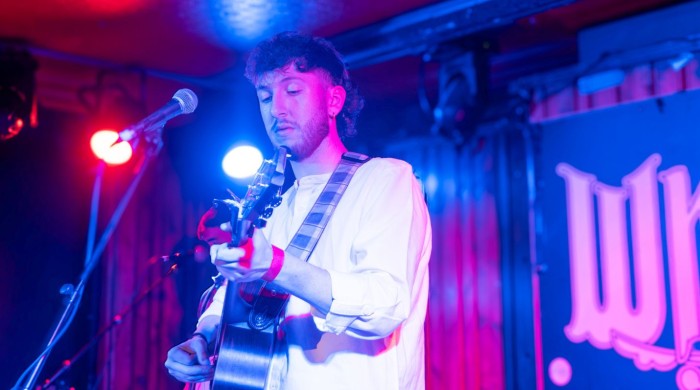Jamie McIntyre performing at Whelans wearing a white shirt and holding a guitar